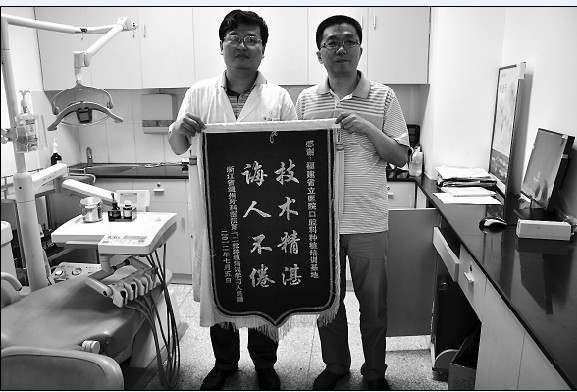 上图为浙江温州牙科医院第一、二批种植培训人员向林毅副主任医师赠送“医术精湛、诲人不倦”的锦旗，感谢种植培训基地精心教学和技术传授。